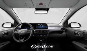Panoramica completa degli interni Hyundai i10 con dettaglio su plancia, volante e display infotainment